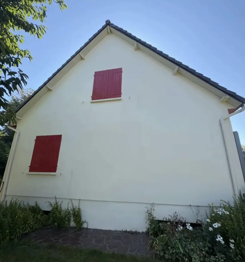 Pignon blanc aux volets rouges après intervention